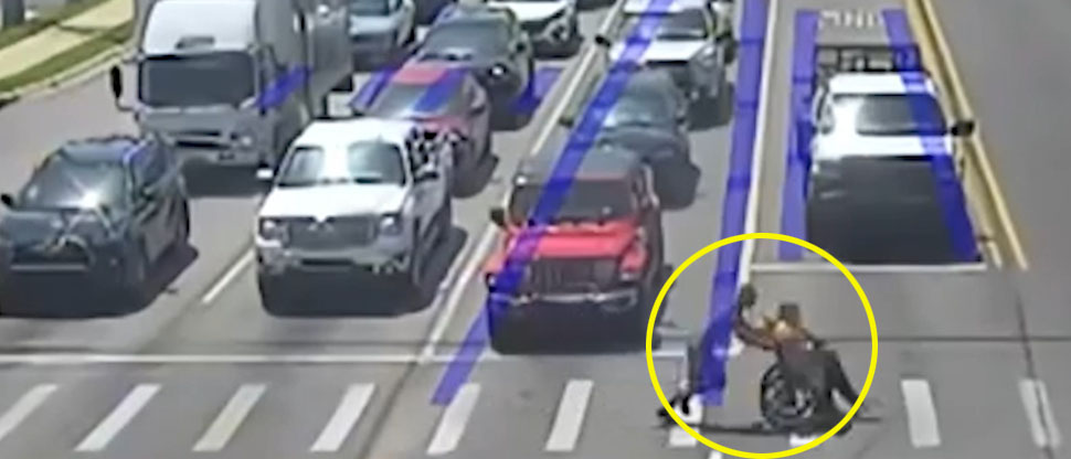 Spiderman usa sus super poderes para ayudar a cruzar la calle a una persona en silla de ruedas