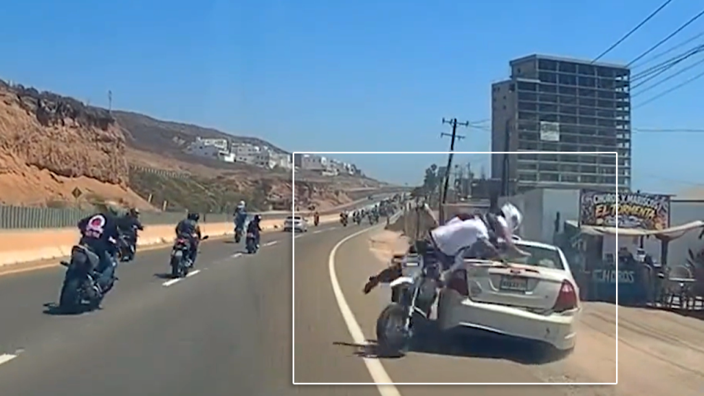 El momento cuando un motociclista se estrella en la parte trasera de un vehículo