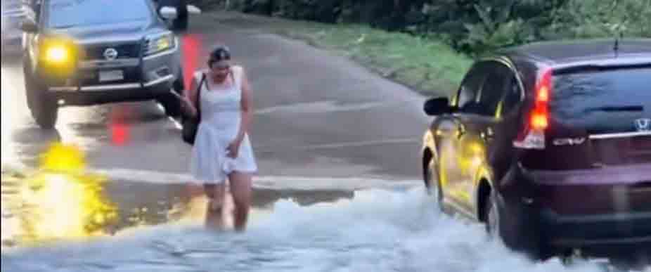 HONDURAS: mujer termina empapada al cruzar una calle inundada